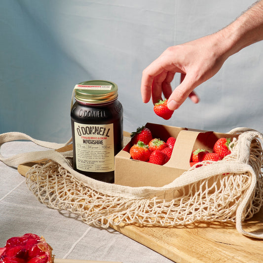 Glas mit Strawberry Cream Likör, dekoriert mit frischen Erdbeeren
