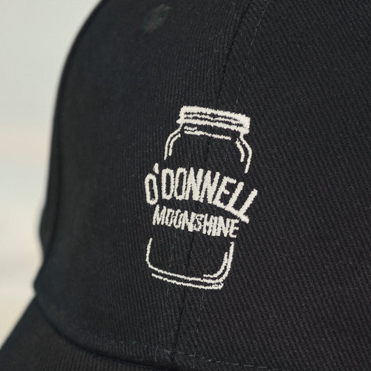 Eine Nahaufnahme des Logos auf der Vorderseite der schwarzen Kappe