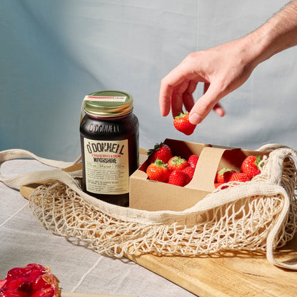 Glas mit Strawberry Cream Likör, dekoriert mit frischen Erdbeeren
