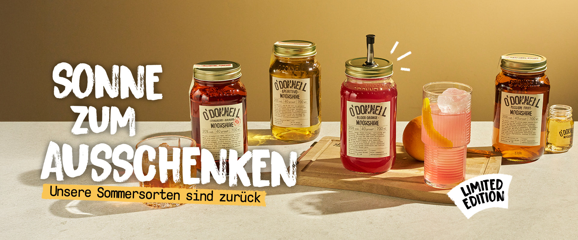 Breitformatiges Landingpage-Banner für O'Donnell Moonshine: Verschiedene farbige Sommersorten, darunter „Blutorange“ mit Ausgießer, stehen neben frischen Cocktails vor warmem Hintergrund.