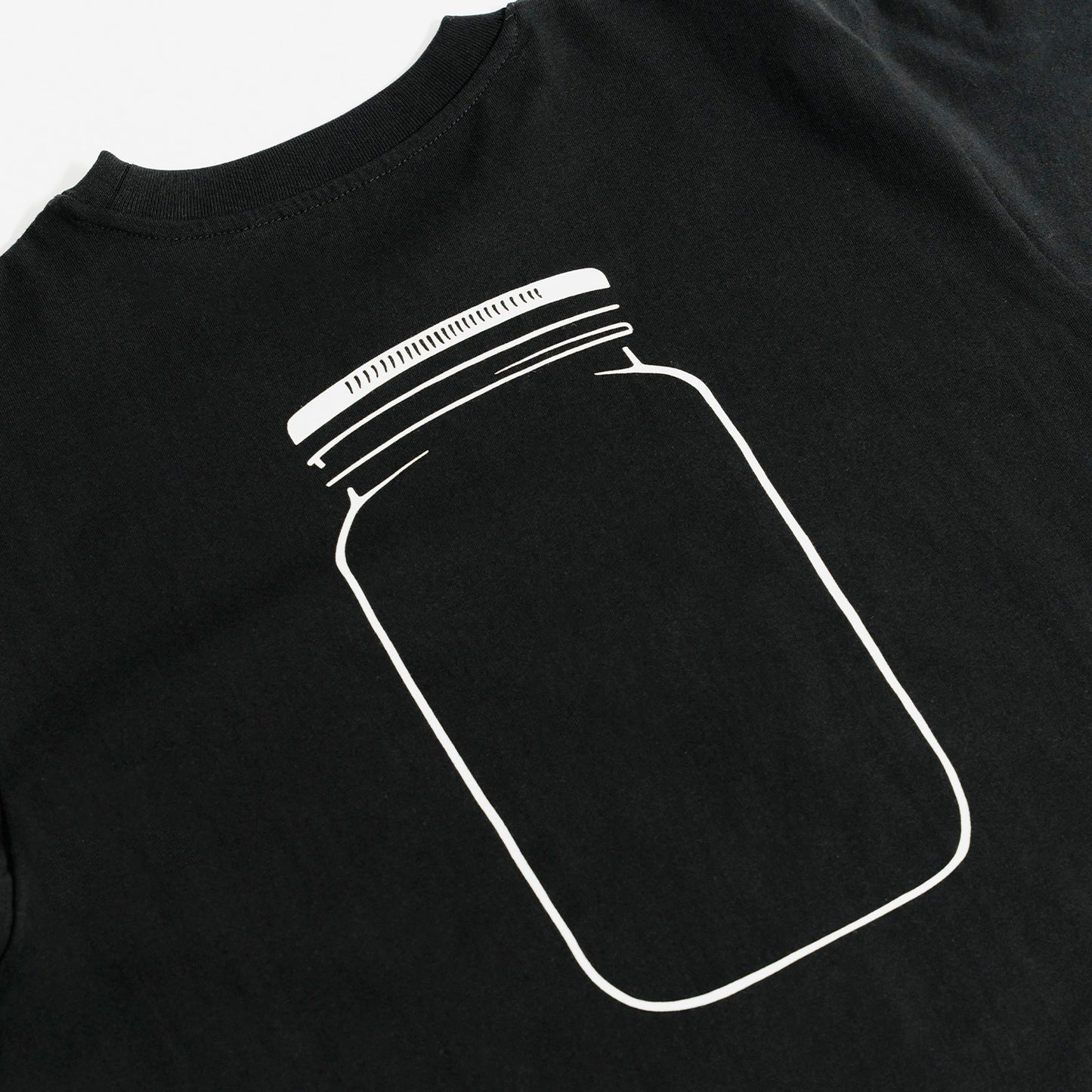 Quadratische Detailansicht für O'Donnell Moonshine: Ein großer, minimalistischer Backprint eines weißen Glaskrugs (Mason Jar) ziert den Rücken eines schwarzen T-Shirts.