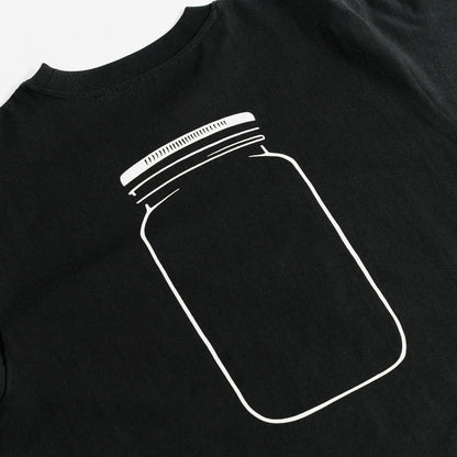 Quadratische Detailansicht für O'Donnell Moonshine: Ein großer, minimalistischer Backprint eines weißen Glaskrugs (Mason Jar) ziert den Rücken eines schwarzen T-Shirts.
