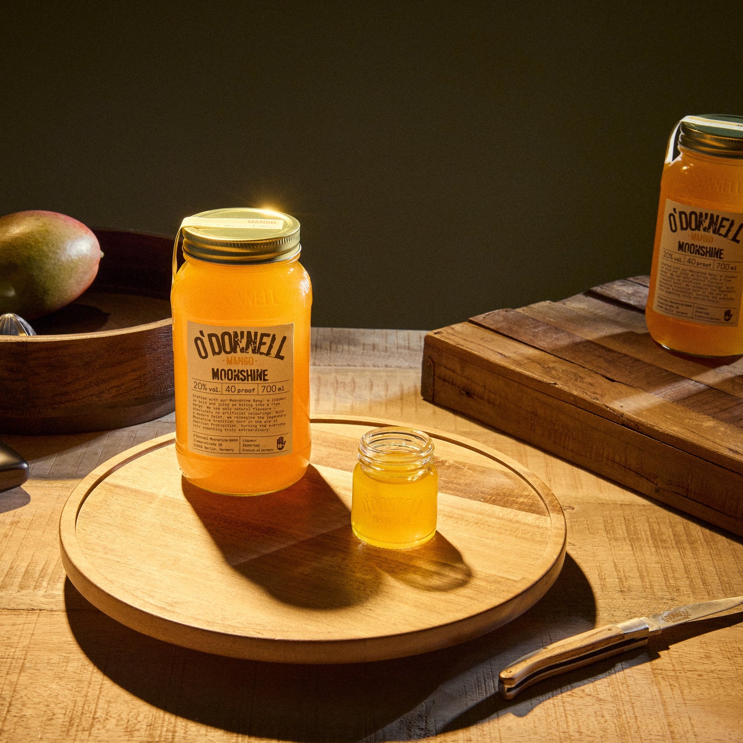 Der O'Donnell Moonshine Golden mango präsentiert mit einem Shot.