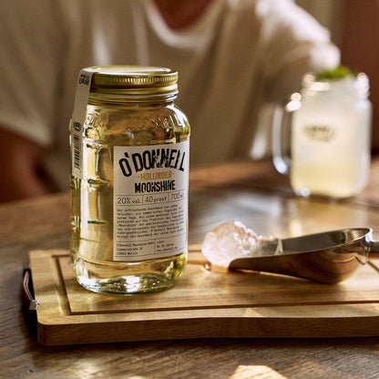 O'Donnell Moonshine  Holunder-Likör mit einem Mason Jar vor einem angerichteten Cocktail.