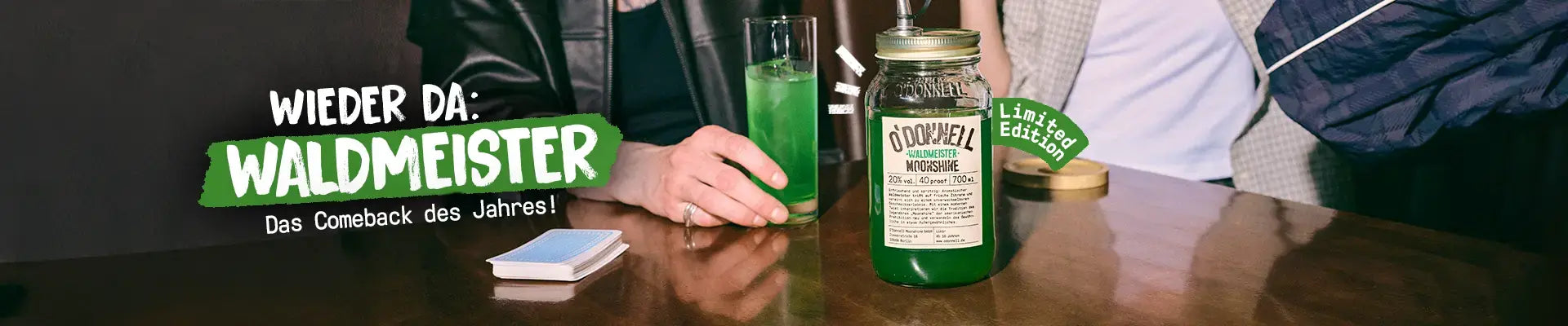 O'Donnell Moonshine Desktop LP Banner für die zurückkehrende Sorte Waldmeister mit 700ml Mason Jar auf einem Kneipentisch.