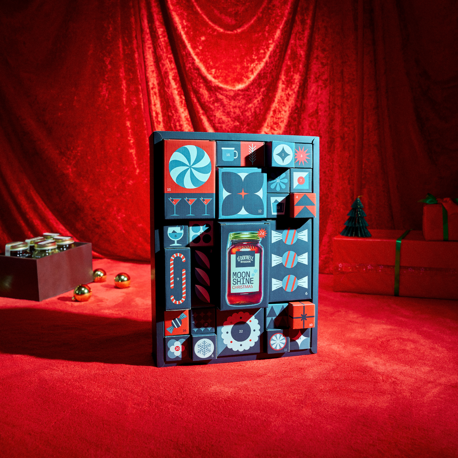 Der O'Donnell Moonshine Adventskalender vor einem Weihnachtlichen rotem Hintergrund.