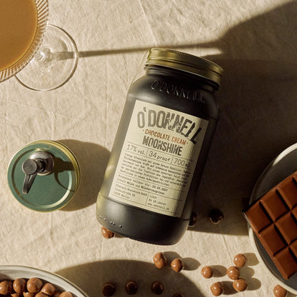 O'Donnell Moonshine Chocolate Cream präsentiert neben einem Ausgießer und für den Geschmack typische Zutaten
