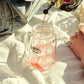 O'Donnell Moonshine Likeur wird in ein Henkelglas mit Eiswürfeln eingegossen – Outdoor-Lifestyle auf Leinentuch, Sonnenlicht
