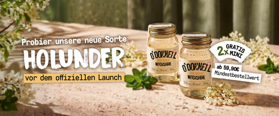 Zwei kleine O'Donnell Moonshine Holunder-Minigläser stehen inmitten von weißen Holunderblüten im warmen Sonnenlicht.
