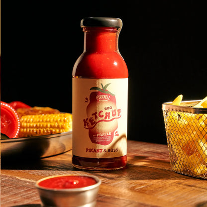O'Donnell Moonshine BBQ Ketchup Pikant & Süss – Flasche zwischen Maiskolben und Pommes-Korb mit Dipschale im Vordergrund, dunkle Food-Atmosphäre