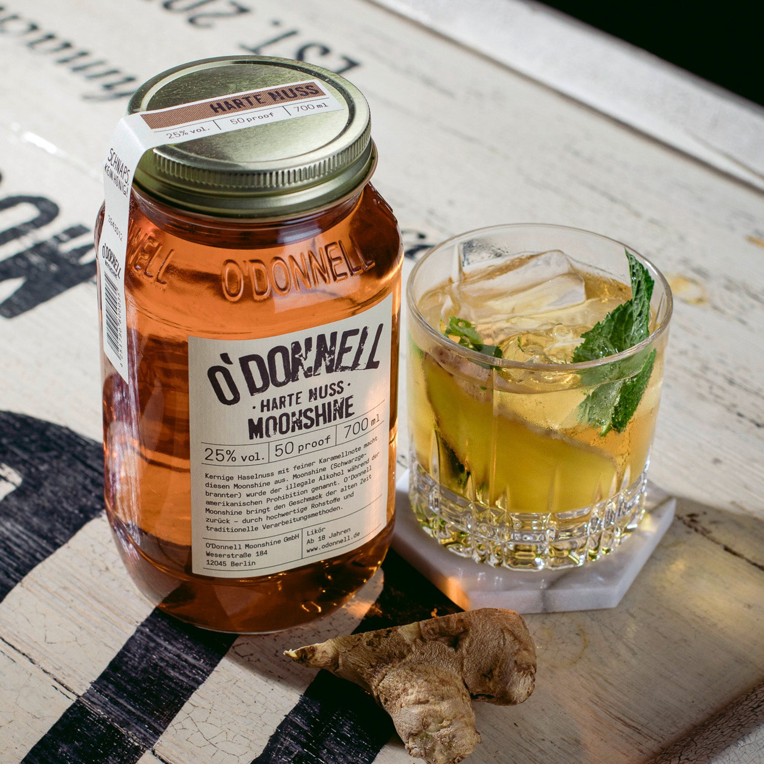 Ein O'Donnell Moonshine Harte Nuss Jar neben einem mit Ginger und Ingwer verfeinertem Longdrink.